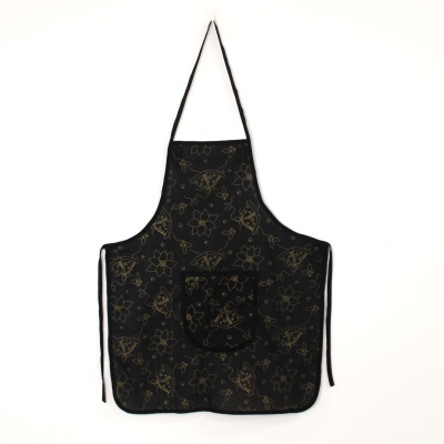 Avental preto com padrão dourado de flores e pássaros e bolso frontal