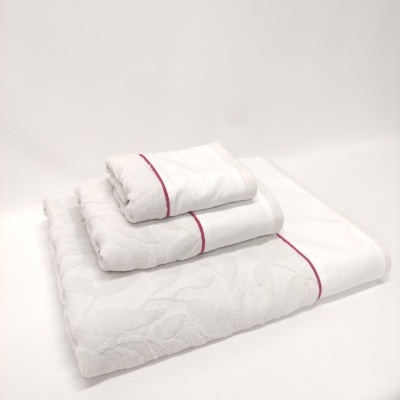 Conjunto de toalhas brancas com padrão floral e risca vermelha em fundo branco.