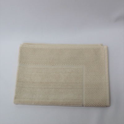 Toalha bege clara dobrada com textura e padrão de pontos