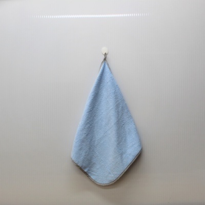 Pano de microfibra azul pendurado numa parede branca