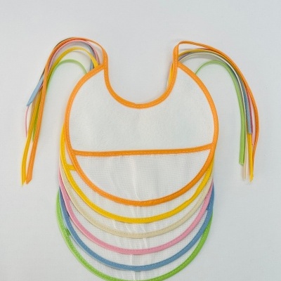 Sete babetes de bebé em algodão branco com bordas coloridas e fitas para amarrar