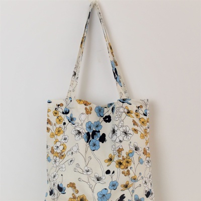 Saco de tecido com padrão floral azul, amarelo e preto