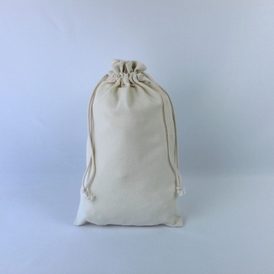 Saco de tecido cru com cordões para fechar sobre fundo branco