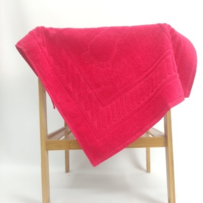 Toalha de banho rosa pendurada numa estrutura de madeira clara