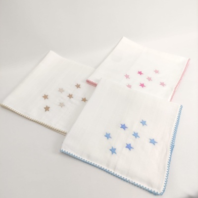 Três panos brancos com bordas coloridas e estrelas bordadas