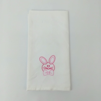Guardanapo branco com bordado rosa de rosto de coelho dobrado