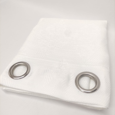 Toalha branca com ilhóses metálicos prateados dobrada