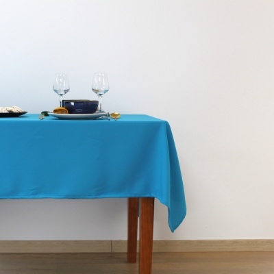 Mesa de madeira com toalha azul e utensílios de mesa