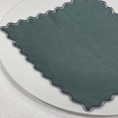 Guardanapo verde com bordas onduladas sobre prato branco