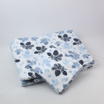 Conjunto têxtil branco com padrão de folhas azuis