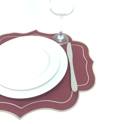 Conjunto de pratos brancos com individual bordô, faca e taça de vidro