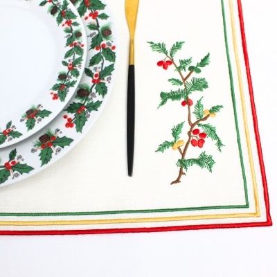 Pratos e guardanapo de tecido com decoração natalícia em fundo branco