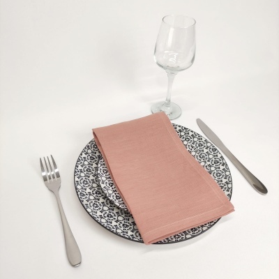 Conjunto de mesa com prato estampado, guardanapo salmão, talheres prateados e copo de vidro