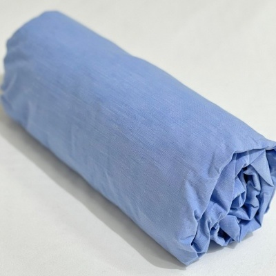 Lençol azul claro enrolado sobre superfície branca