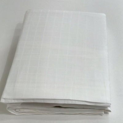 Lençol branco dobrado com padrão quadriculado