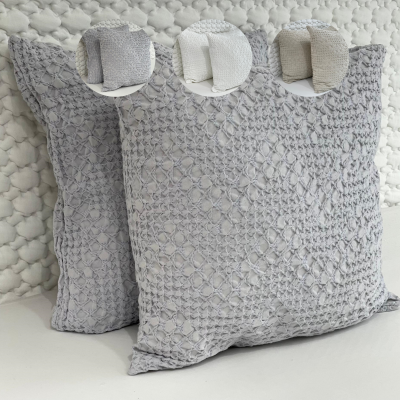 Almofadas cinza claro com padrão texturizado em fundo bege