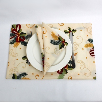 Jogo americano e guardanapo com padrão natalino em tecido bege, prato branco, garfo e faca.