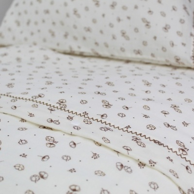 Lençóis de cama branca com padrão floral castanho e bordado decorativo