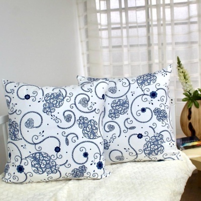 Duas almofadas brancas com padrão azul de arabescos e flores