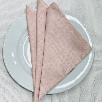 Guardanapo rosa claro sobre prato branco redondo