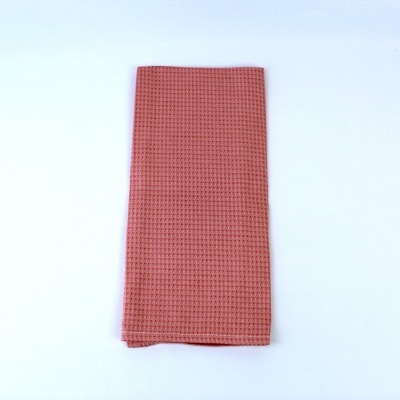 Toalha cor de rosa salmão texturizada tipo favo de mel dobrada