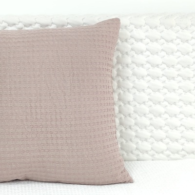 Almofada cor de rosa com textura sobre superfície branca texturizada