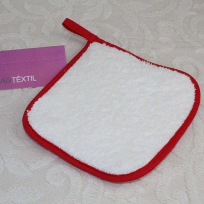 Pega-panela branco com bordas vermelhas em superfície bege clara com cartão roxo ao lado