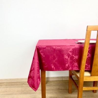 Toalha de mesa cor-de-rosa com padrão floral sobre mesa de madeira