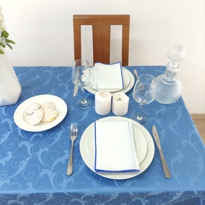 Mesa posta com toalha azul e utensílios à mesa