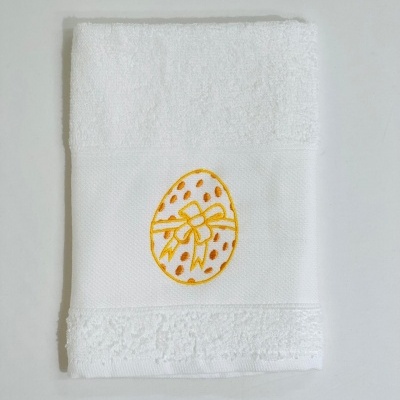 Toalha branca com bordado amarelo de ovo decorado com fita