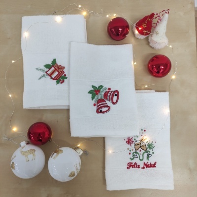 Toalhas brancas natalícias bordadas com decorações, bolas de Natal vermelhas e brancas douradas, luzes e enfeite de gnomo