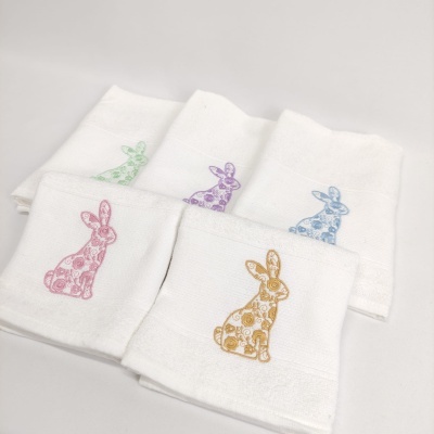 Toalhas brancas com bordados de coelhos coloridos com padrão floral