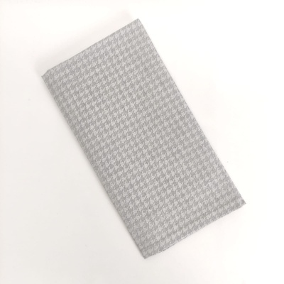 Toalha dobrada com padrão pied-de-poule cinzento e branco