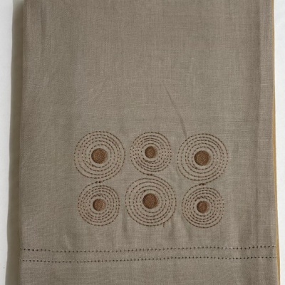 Pano de linho bege com bordados circulares castanhos