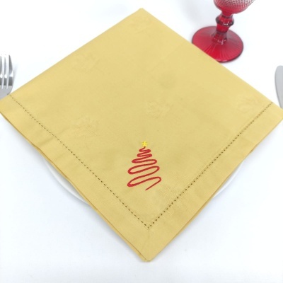 Guardanapo amarelo com bordado de árvore de Natal vermelho e estrela amarela