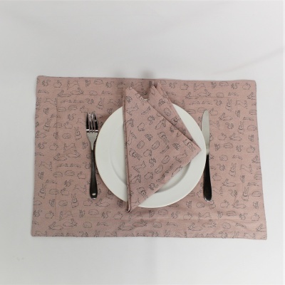 Lugar americano e guardanapo rosa com padrões de utensílios de cozinha, prato branco, garfo preto e faca prateada