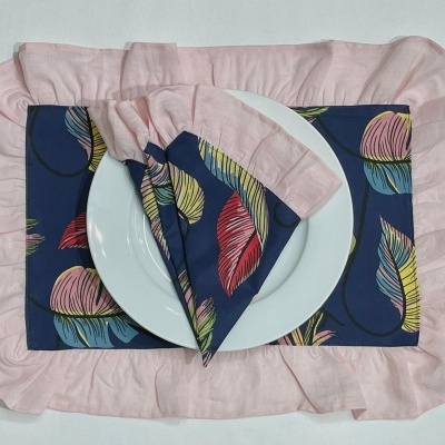 Jogo americano e guardanapo com estampa de folhas coloridas e pratos brancos