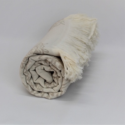 Manta ou toalha bege com padrão floral e franjas