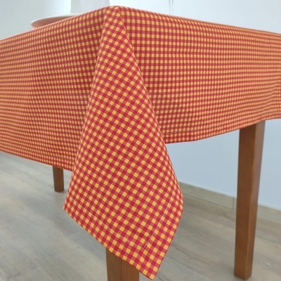 toalha de mesa aos quadrados vermelhos e amarelos sobre mesa de madeira