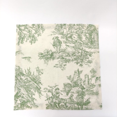 Guardanapo de tecido com padrão verde de cenas campestres em fundo creme dobrado