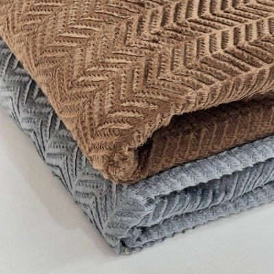 Duas mantas dobradas com padrão de espinha de peixe, castanha e cinza