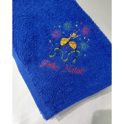 Toalha azul com bordado de Natal com taças e texto