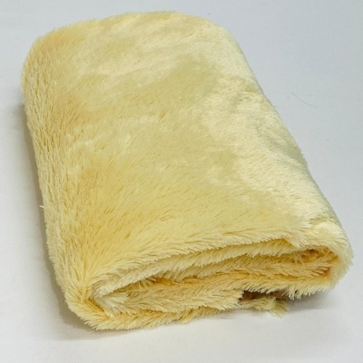 Toalha felpuda amarelo claro dobrada sobre fundo branco