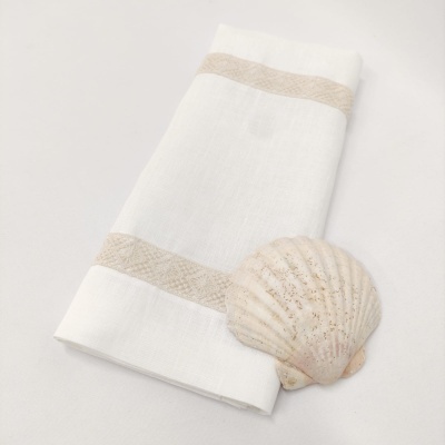 Toalha branca com faixas bege e concha marinha