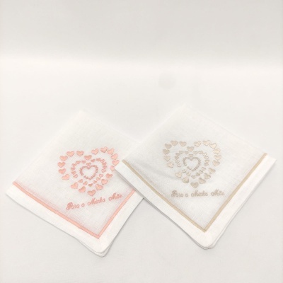 Dois lenços brancos com bordados em forma de coração e texto 