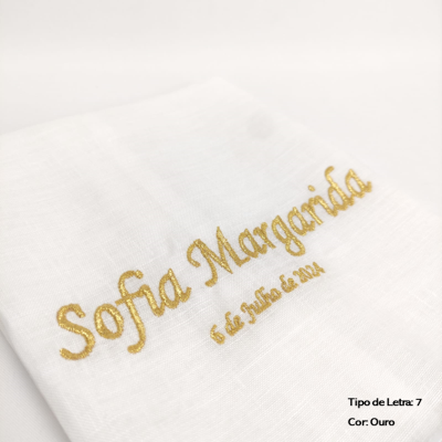 Pano branco com bordado dourado a dizer Sofia Margarida e 6 de Julho de 2024