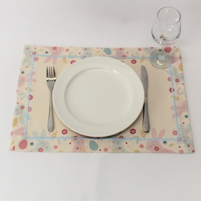 Lugar americano floral com prato branco, talheres e taça de vidro