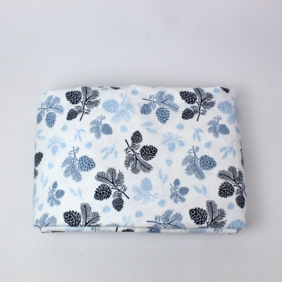 Tecido branco com padrão de pinhas em azul e preto