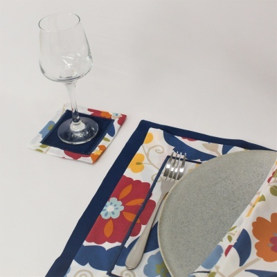 Utensílios de mesa com padrão floral colorido e prato cinza claro