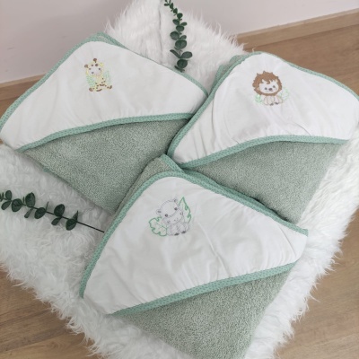 Toalhas de bebê com capuz verde claro e branco com bordados de girafa, leão e elefante.